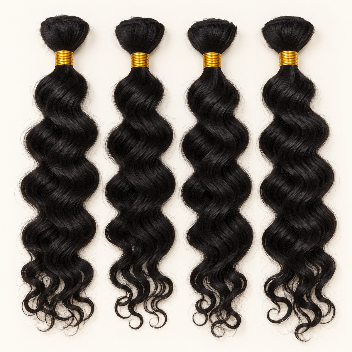 Four separate black wavy hair bundles with gold ties on ivory.